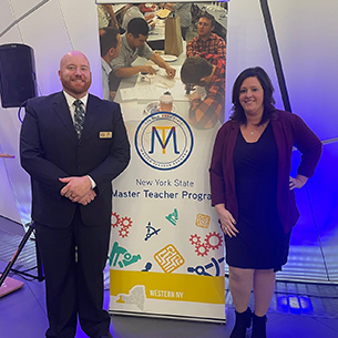  Jim Roland and Nicole Costello standing next to a Master Teacher banner